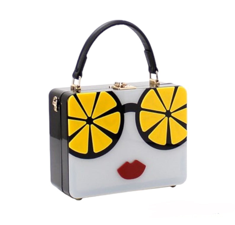 Black handbag with lemon glasses and red lips