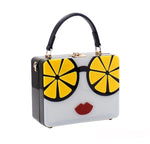 Load image into Gallery viewer, Black handbag with lemon glasses and red lips
